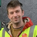 Dan has short brown hair and is wearing a PCS high-vis jacket